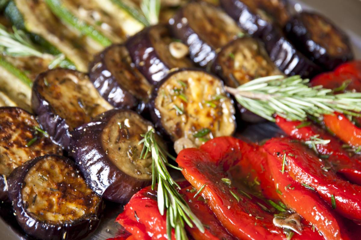 A vegan antipasto platter of grilled eggplant, zucchini and roasted red peppers with rosemary.